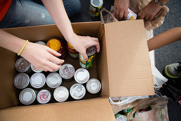 Image of people stocking a box with canned food for a food drive
