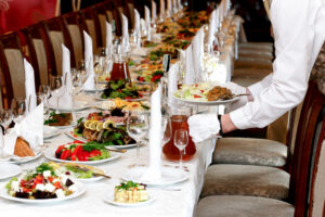 catering server dropping off a plate of food before guests arrive