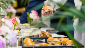 Man grabbing catered lunch sandwiches off a platter