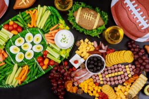 Party table with food and drink for watching american football game.